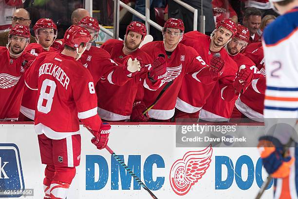 Justin Abdelkader of the Detroit Red Wings pounds gloves with teammates on the bench after his first period goal during an NHL game against the...