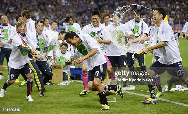 Japan - Japan players pour water over captain Makoto Hasebe in celebration after drawing 1-1 with Australia in a World Cup soccer qualifier at...