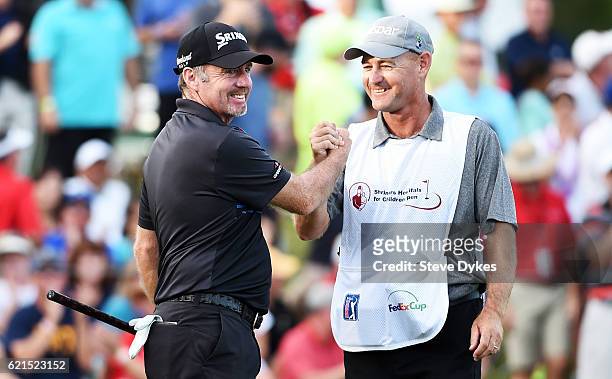 Rod Pampling of Australia celebrates with his caddie Brendan Woolley after putting for birdie to win on the 18th green during the final round of the...