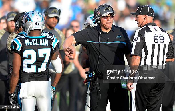 Carolina Panthers head coach Ron Rivera congratulates cornerback Robert McClain as he talks with line judge Tom Stephan while playing against the Los...