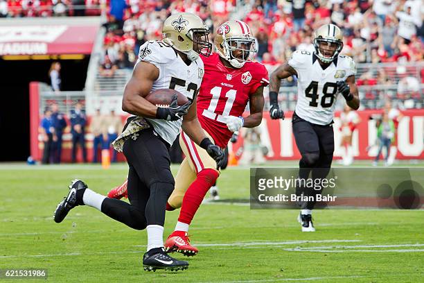 Linebacker Craig Robertson of the New Orleans Saints runs with an interception against wide receiver Quinton Patton of the San Francisco 49ers in the...