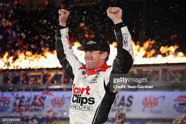 Carl Edwards, driver of the Sport Clips Toyota, celebrates in Victory Lane after winning the rain-shortened NASCAR Sprint Cup Series AAA Texas 500 at...