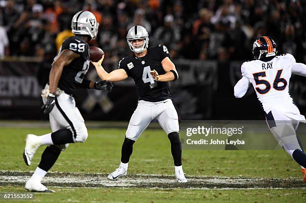 Oakland Raiders quarterback Derek Carr throws a pass to Oakland Raiders tight end Clive Walford as Denver Broncos outside linebacker Shane Ray moves...