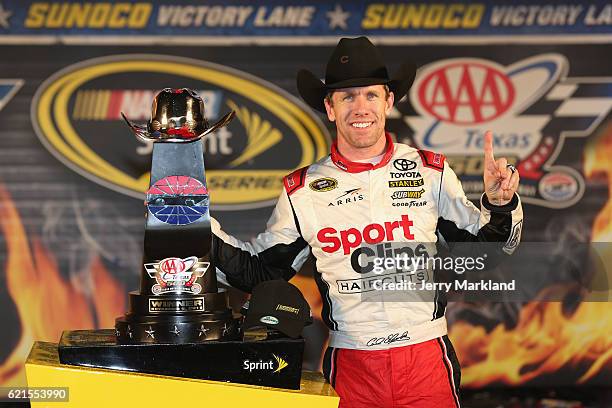 Carl Edwards, driver of the Sport Clips Toyota, poses in Victory Lane after winning the rain-shortened NASCAR Sprint Cup Series AAA Texas 500 at...