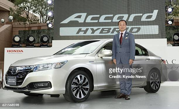 Japan - Honda Motor Co. President Takanobu Ito poses in front of the Accord hybrid vehicle in Tokyo on June 20, 2013. The new sedan vehicle,...