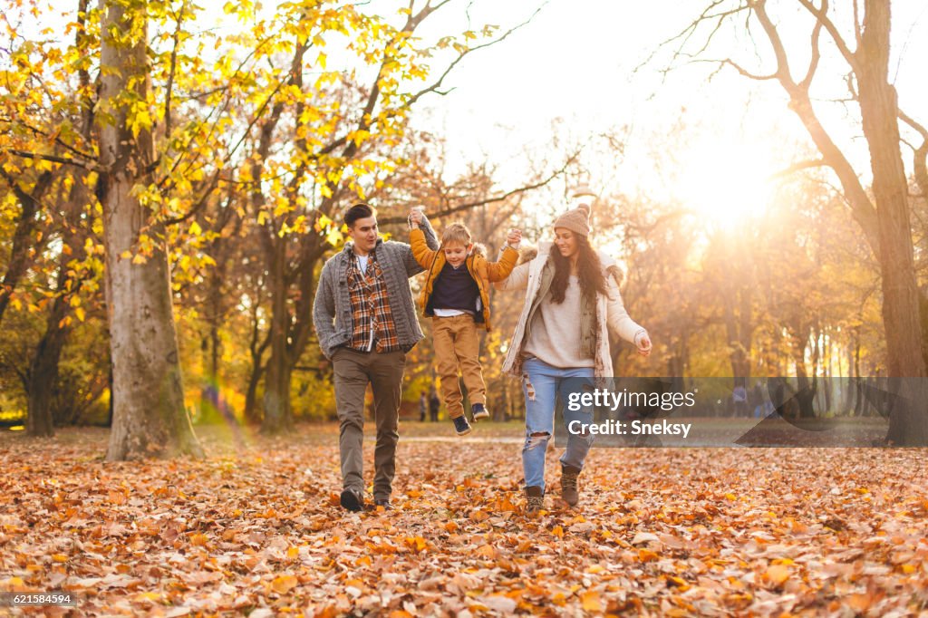 Family playing in autumn leaves