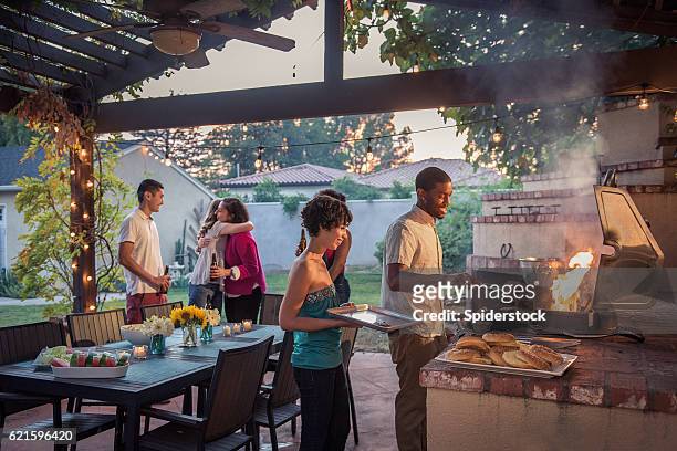 hipsters grilling at a summer backyard bbq - dinner party stock pictures, royalty-free photos & images