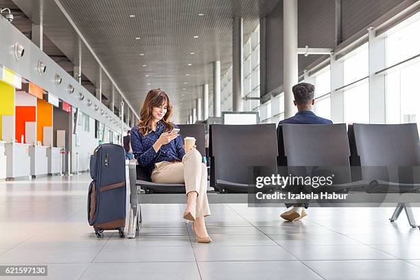 woman waiting for flight at the airport lounge - airport waiting lounge imagens e fotografias de stock