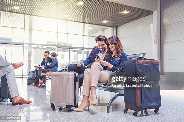 people waiting for flight at airport lounge - suitcase couple stockfoto's en -beelden