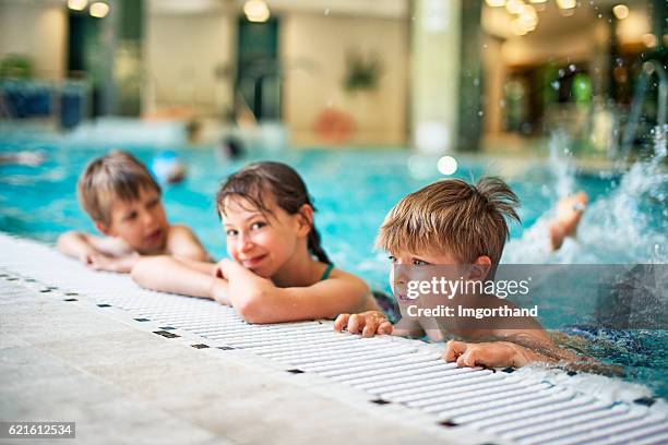 kids learning to swim in indoors swimming pool - leren zwemmen stockfoto's en -beelden