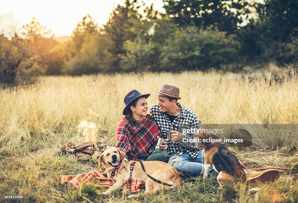 Couple drinking tea in front of bonfire