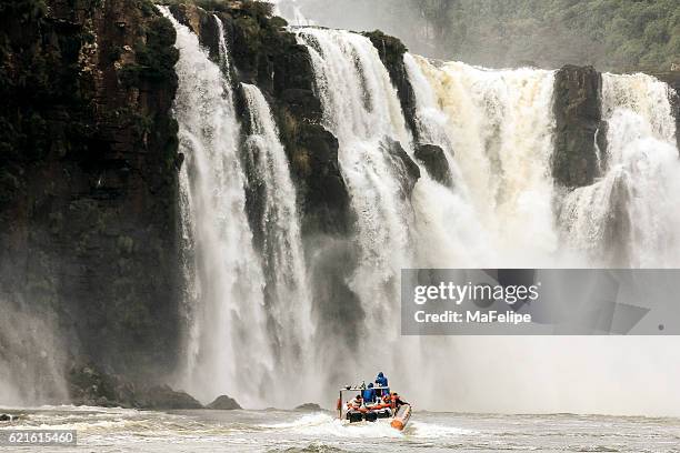 little boat aproaching iguazu falls - small waterfall stock pictures, royalty-free photos & images