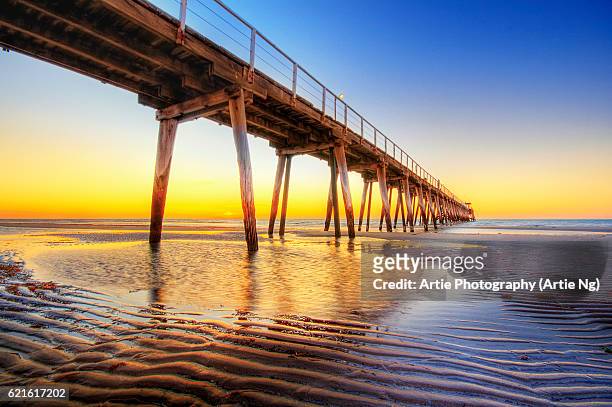 sunset view of largs bay jetty on the lefevre peninsula in the west of adelaide, south australia - bay adelaide stock pictures, royalty-free photos & images