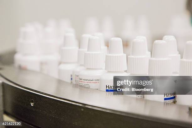 Russian cyrillic script sits on bottles of Nasavin nasal spray as they pass through a labeling machine inside Merck KGaA's pharmaceutical...