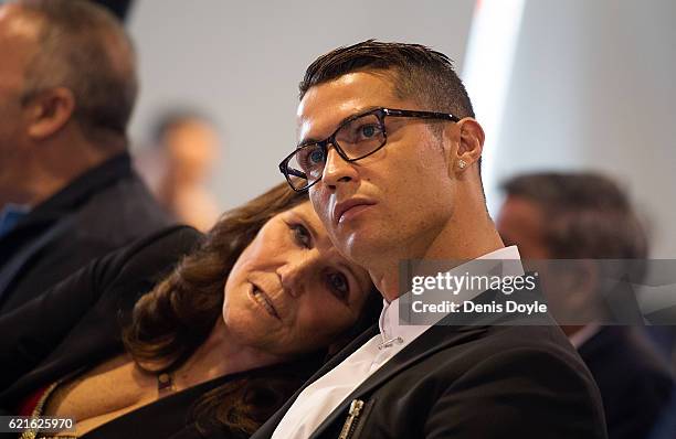 Cristiano Ronaldo of Real Madrid looks on with his mother Maria Dolores dos Santos Aveiro during his press conference after signing a new five-year...