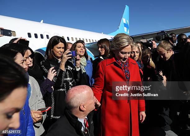 Members of the traveling press surround Democratic presidential nominee former Secretary of State Hillary Clinton before she boards her campaign...