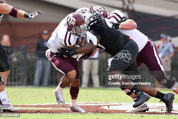 Texas A&M Aggies running back Trayveon Williams is tackled by Mississippi State Bulldogs defensive lineman A.J. Jefferson during the football game...