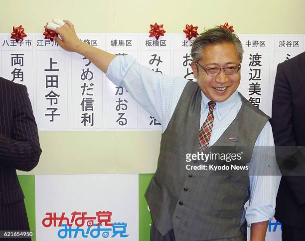 Japan - Your Party leader Yoshimi Watanabe places a rose ornament above the name of the party's successful candidate in the Tokyo metropolitan...