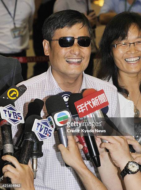Taiwan - Exiled Chinese human rights activist Chen Guangcheng smiles to reporters after arriving at an airport near Taipei, Taiwan, on June 23, 2013.