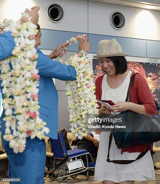 Japan - A passenger receives a lei from a Hawaiian Airlines employee at Sendai airport in northeastern Japan on June 26 the day the U.S. Carrier...