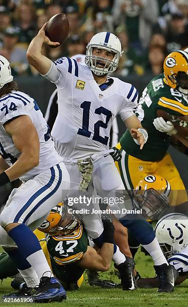 Andrew Luck of the Indianapolis Colts passes as he is hit by Jake Ryan of the Green Bay Packers at Lambeau Field on November 6, 2016 in Green Bay,...