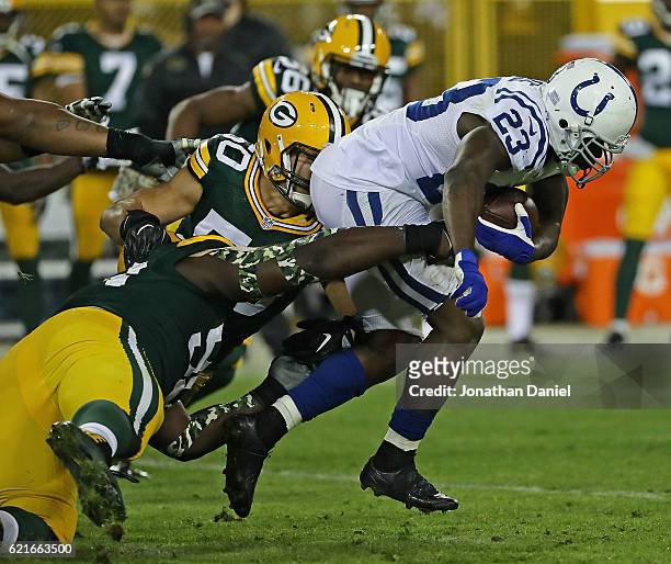 Frank Gore of the Indianapolis Colts is tripped up by Blake Martinez and Letroy Guion of the Green Bay Packers at Lambeau Field on November 6, 2016...
