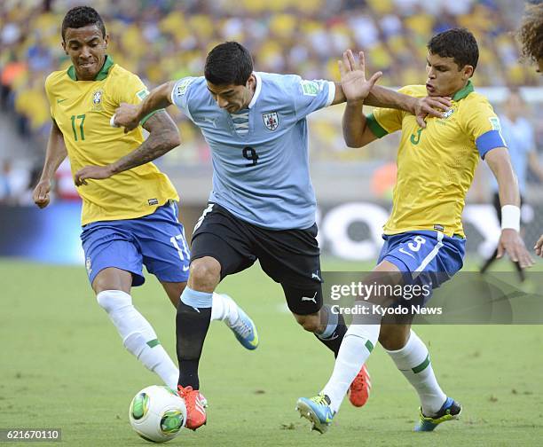 Brazil - Uruguay forward Luis Suarez fends off Luiz Gustavo and Thiago Silva of Brazil during the first half of a Confederations Cup semifinal in...