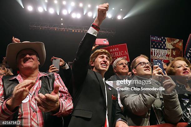 Jonathan Pozzie pumps his fist in the air as he watches Republican presidential nominee Donald Trump speak during a campaign rally at the SNHU Arena...