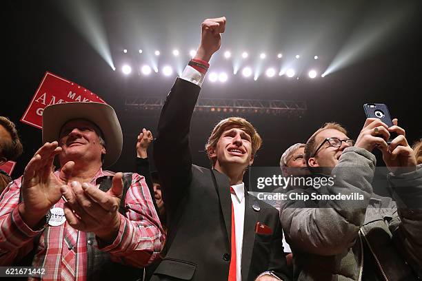 Jonathan Pozzie pumps his fist in the air as he watches Republican presidential nominee Donald Trump speak during a campaign rally at the SNHU Arena...