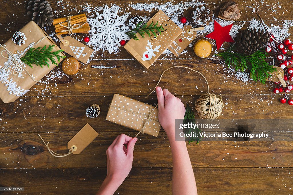 Creative hobby. Girl's hands show christmas holiday handmade present in craft paper