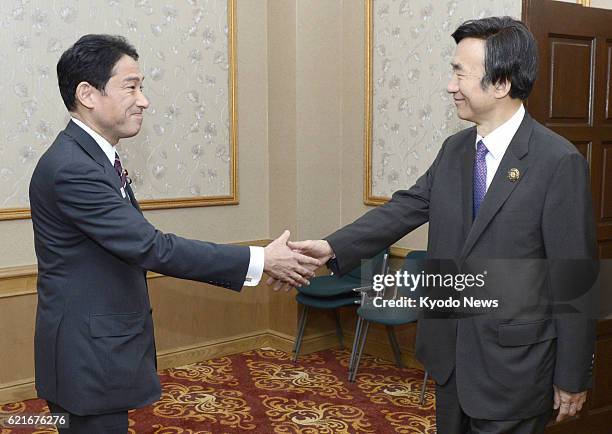 Brunei - Japanese Foreign Minister Fumio Kishida and his South Korean counterpart Yun Byung Se shake hands prior to holding talks in Bandar Seri...