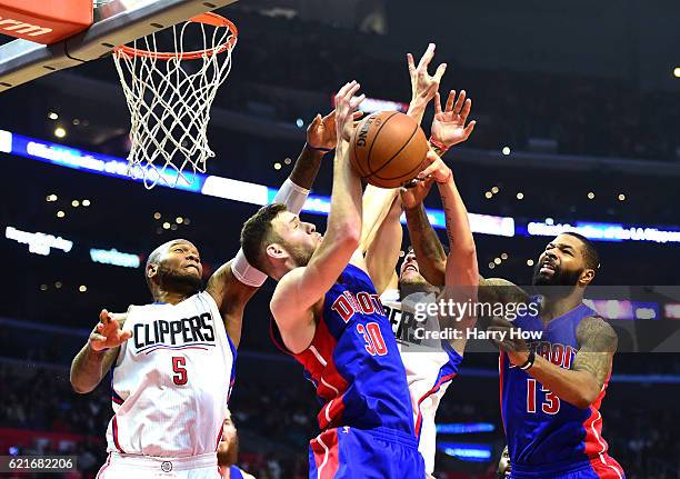 Marreese Speights and Austin Rivers of the Los Angeles Clippers reach for a rebound against Jon Leuer and Marcus Morris of the Detroit Pistons during...