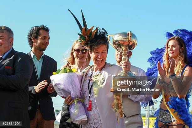 Glenys Kennard part owner celebrates with the NZ Trotting Cup after Lazarus wins Race 10 during New Zealand Trotting Cup Day at Addington Raceway on...