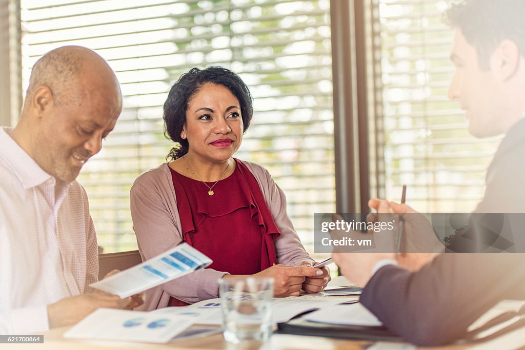 Insurance agent talking to older couple of african ethnicity