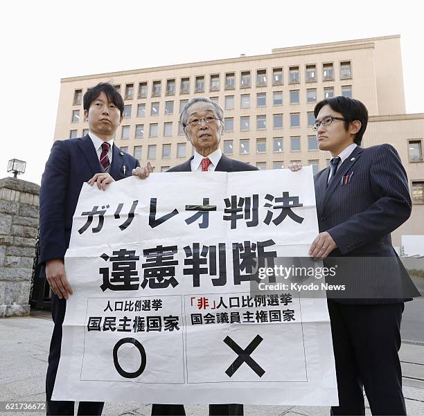 Plaintiffs' lawyers hold a banner outside the Sendai High Court with a message criticizing a ruling by the court in northeastern Japan on Nov. 7...