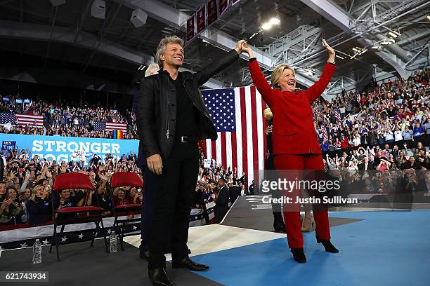 Democratic presidential nominee former Secretary of State Hillary Clinton raises her arms with musician Jon Bon Jovi during a campaign rally at North...