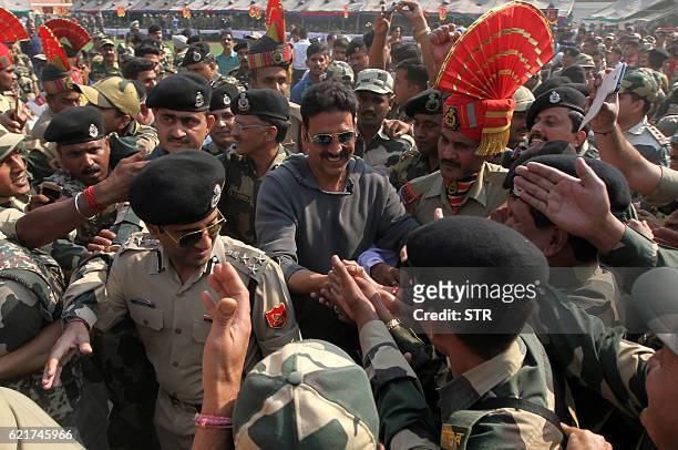 Indian Bollywood actor Akshay Kumar shakes hands with soldiers during a function at Border Security Force Headquarters in Jammu on November 8, 2016....