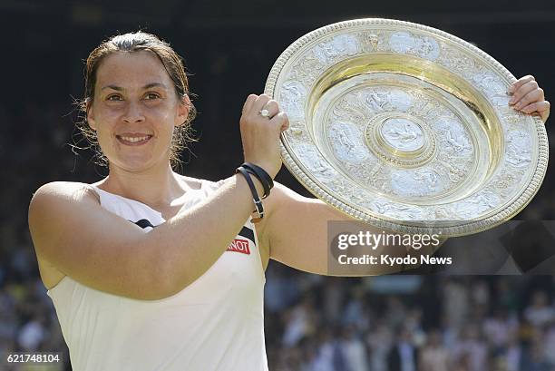 United Kingdom - Marion Bartoli of France holds the winner's trophy after her victory in the women's singles final against Sabine Lisicki of Germany...