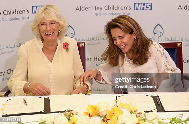 Camilla, Duchess of Cornwall and Princess Haya Bint Al Hussein laugh as they sign a commercial agreement between Alder Hey and Al Jalila Children's...