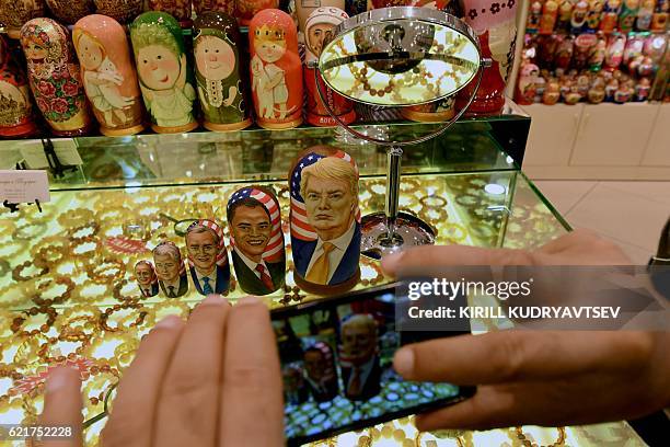 Man takes pictures of traditional Russian wooden nesting dolls, Matryoshka dolls, depicting US Republican presidential nominee Donald Trump, US...