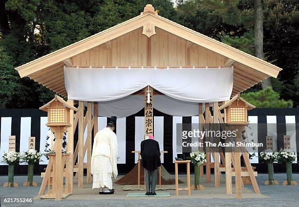 Emperor Akihito bows after offering the 'Tamagushi' sacred tree at an alter of the grave of late Prince Mikasa at Toshimagaoka Cemetery on November...