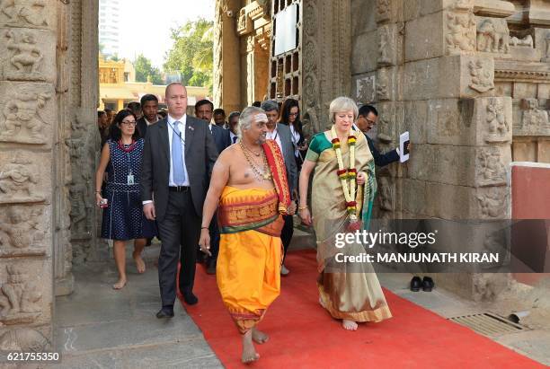 Britain's Prime Minister, Theresa May walks with a Hindu priest during a visit to the Someshwara Temple in Bangalore on November 8, 2016. - Britain's...