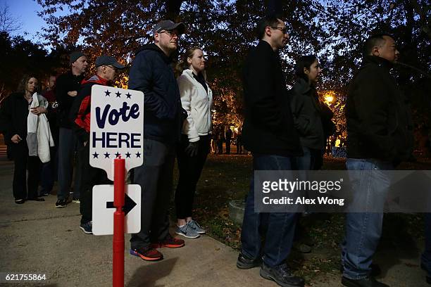 Voters wait in-line for casting their ballots outside a polling place on Election Day November 8, 2016 in Alexandria, Virginia. Americans across the...