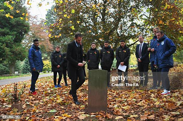 In this handout image provided by the FA, Gareth Southgate interim manager of England places a flower on a war grave as Daniel Sturridge, Joe Hart...