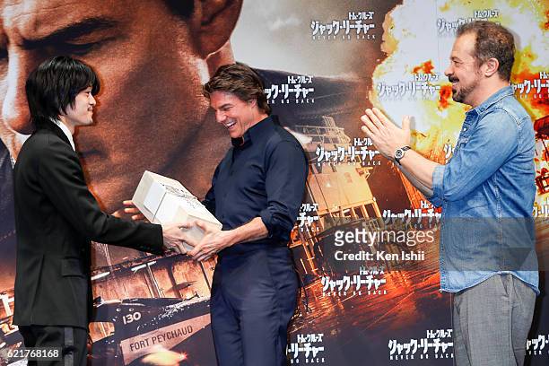 Sosuke Ikematsu presents a gift of Japanese sake to Tom Cruise and Edward Zwick during the press conference and photocall of the Paramount Pictures'...