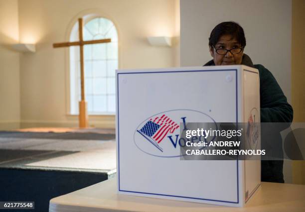 Woman cast her ballot at a church polling station in Fairfax, Virginia during the US presidential election on November 8, 2016.