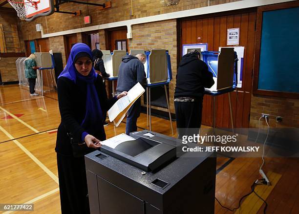 Fatemeh Hussain puts her ballot in the scanner to be tabulated after voting at Oakman Elementary School during the US presidential election on...