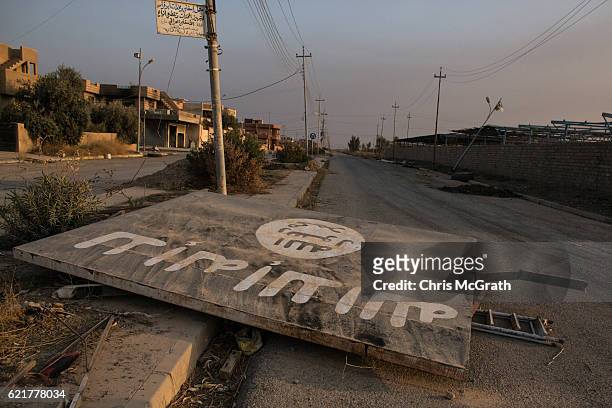 An ISIL billboard is seen destroyed in the middle of the road on November 8, 2016 in Qaraqosh, Iraq. The NPU is a military organization made up of...