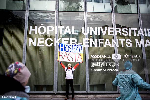 Man holding a sign reading Hosterity, a word game with hospital, in front of the Necker hospital during a demonstration from the Hospital staff...