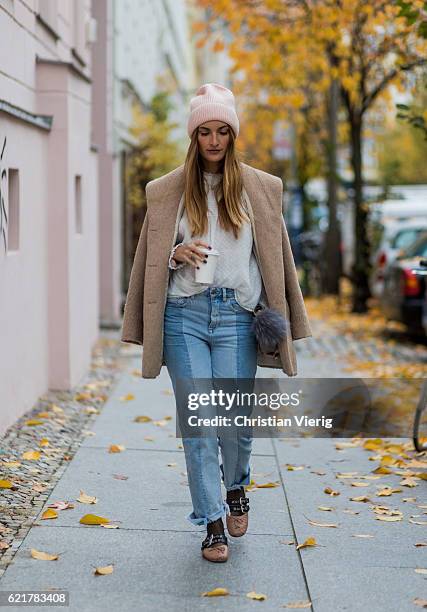 Fashion Blogger and Owner of SCIC Swimwear Sofia Grau holding a coffee to go wearing light blue two tone H&M denim jeans, a pink wool hat &other...